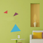 Modern living room with colorful geometric wall decals and a cozy couch.
